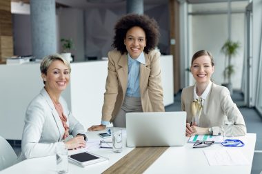 Team of happy businesswomen working in the office and looking at Group of happy female entrepreneurs having a business meeting in the office and looking at camera.